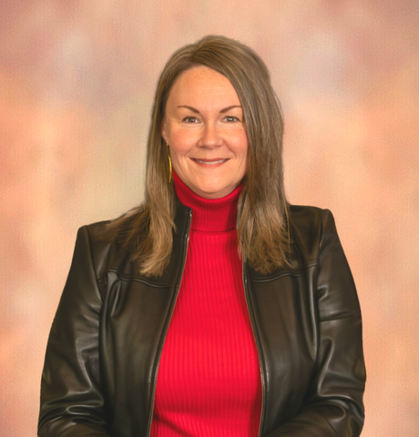 Woman with blonde hair in red blazer smiles at camera.