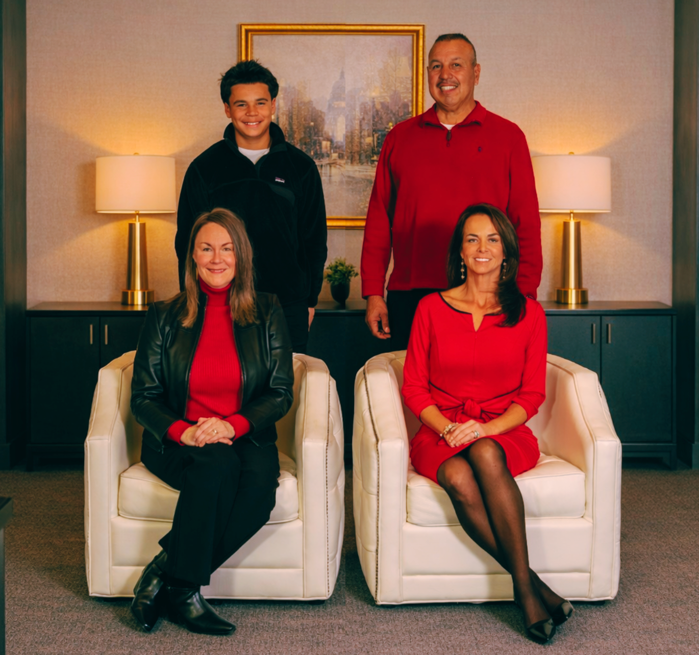 Group photo: five formally dressed people, including a child, against a blurred backdrop.