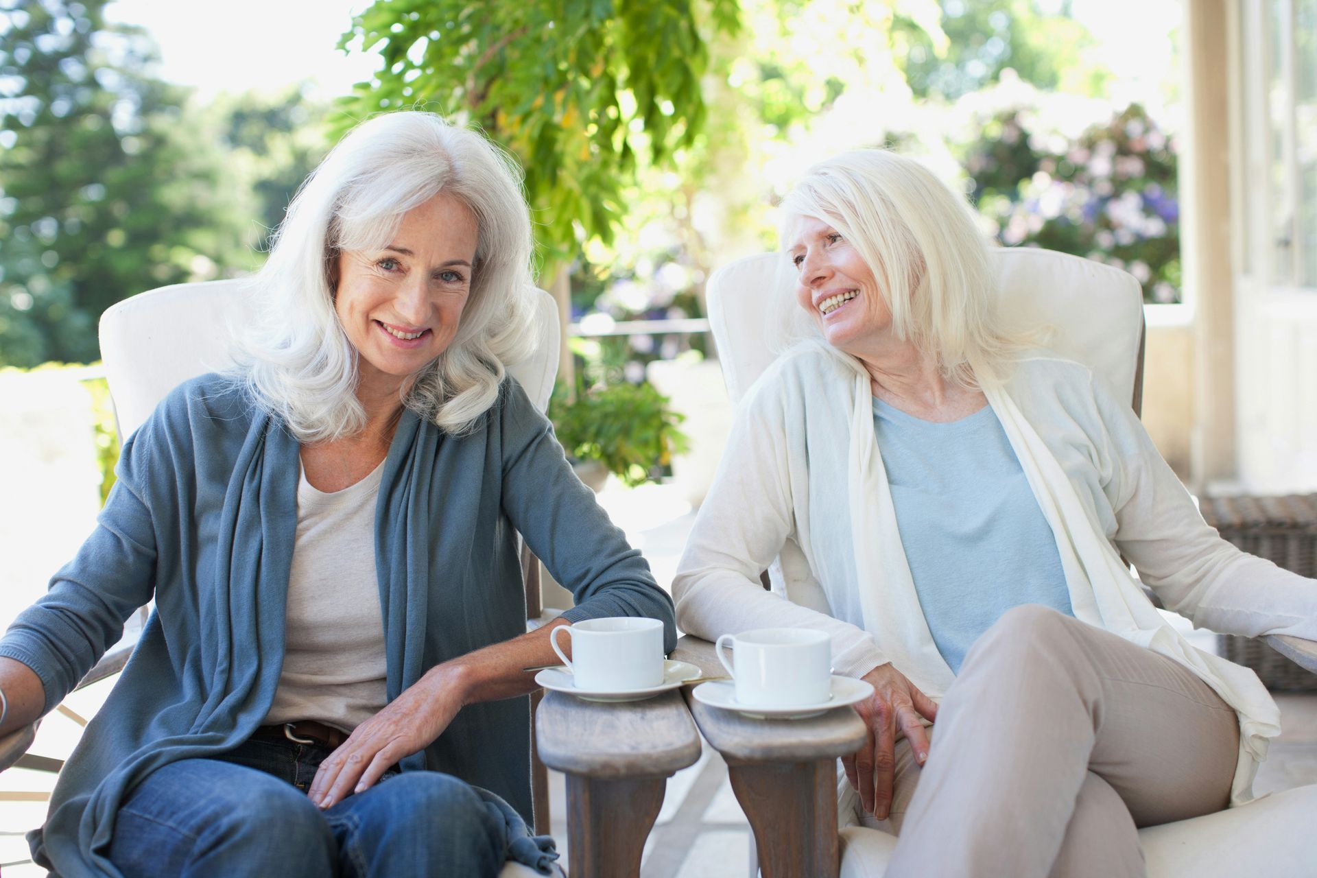 Three people fly fishing by a river, wearing waders. Mountains in the background.