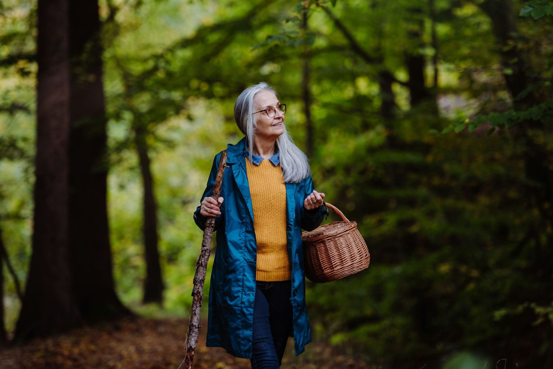 Three people fly fishing by a river, wearing waders. Mountains in the background.