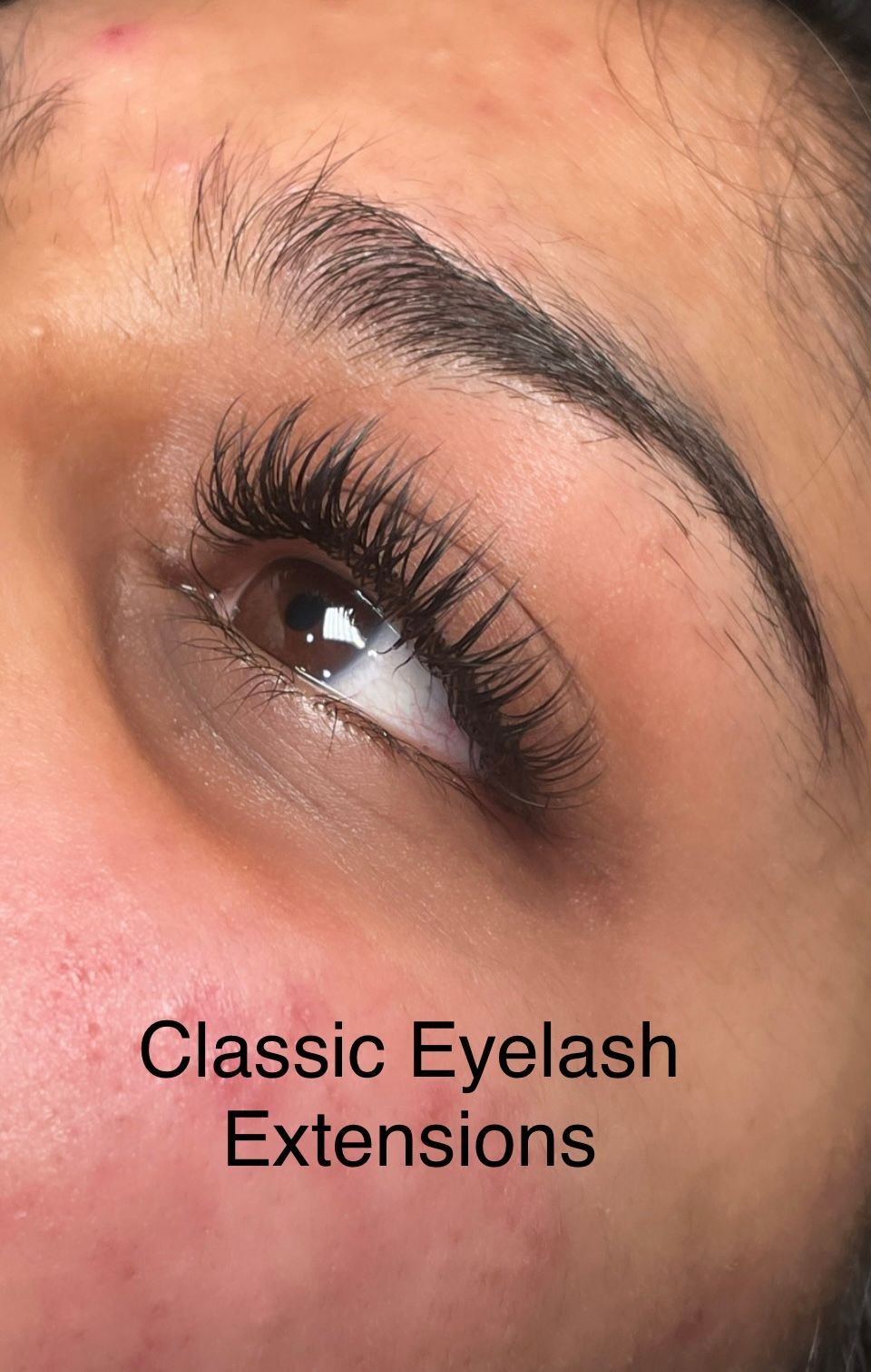 A close up of a woman 's eye with classic eyelash extensions.