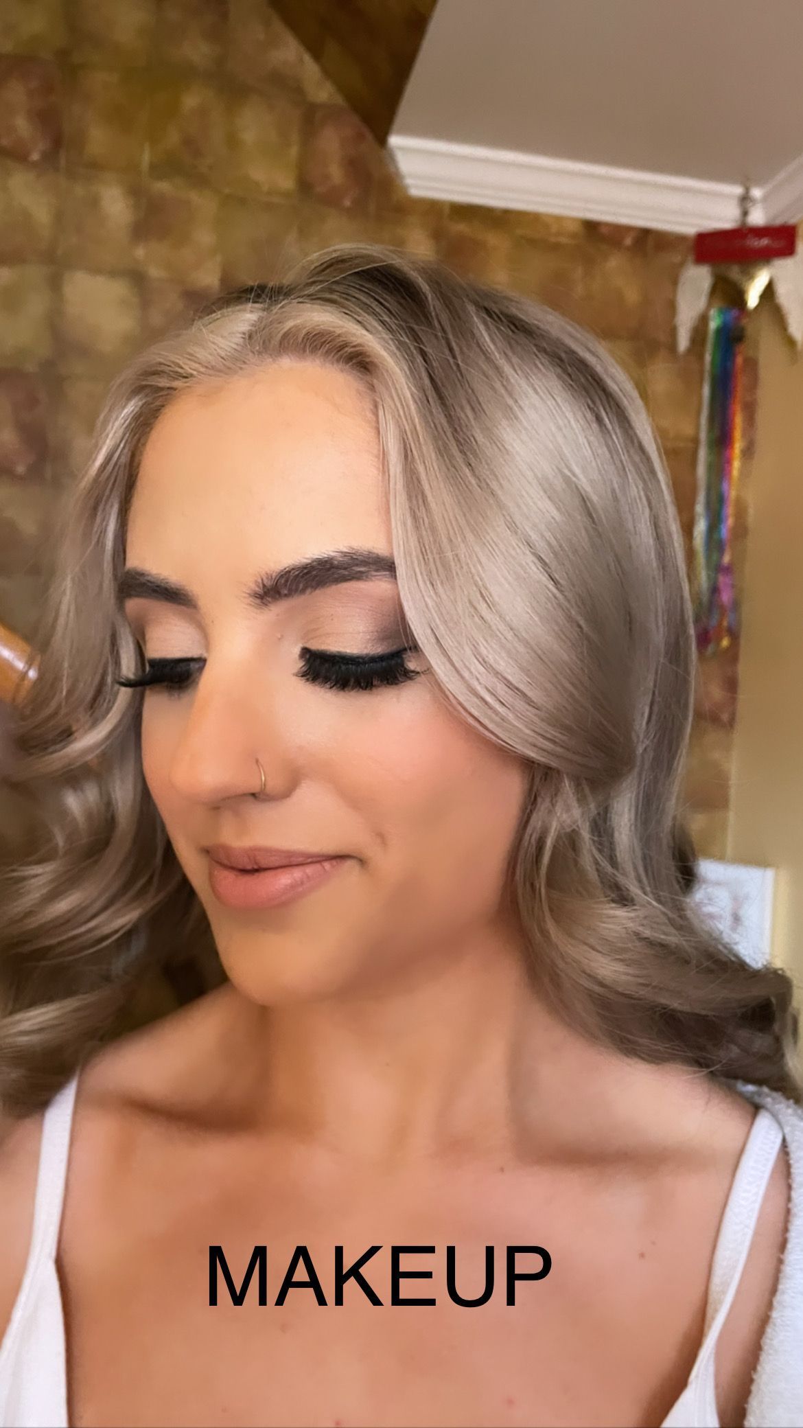 A woman is getting her makeup done by a makeup artist.