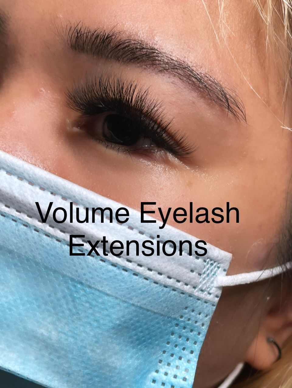 A close up of a woman wearing a mask with eyelash extensions.