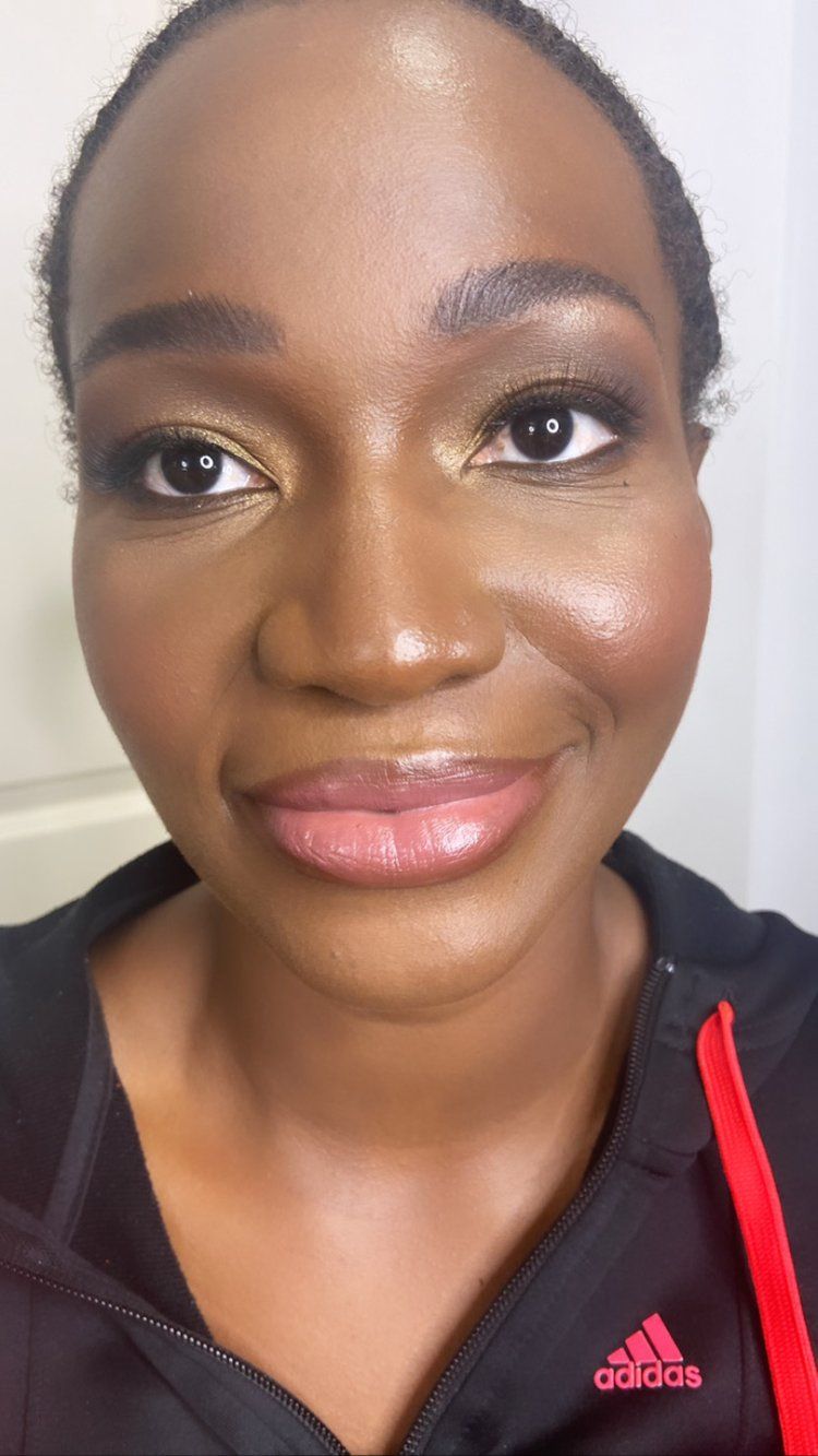 A close up of a woman 's face wearing a black adidas shirt.