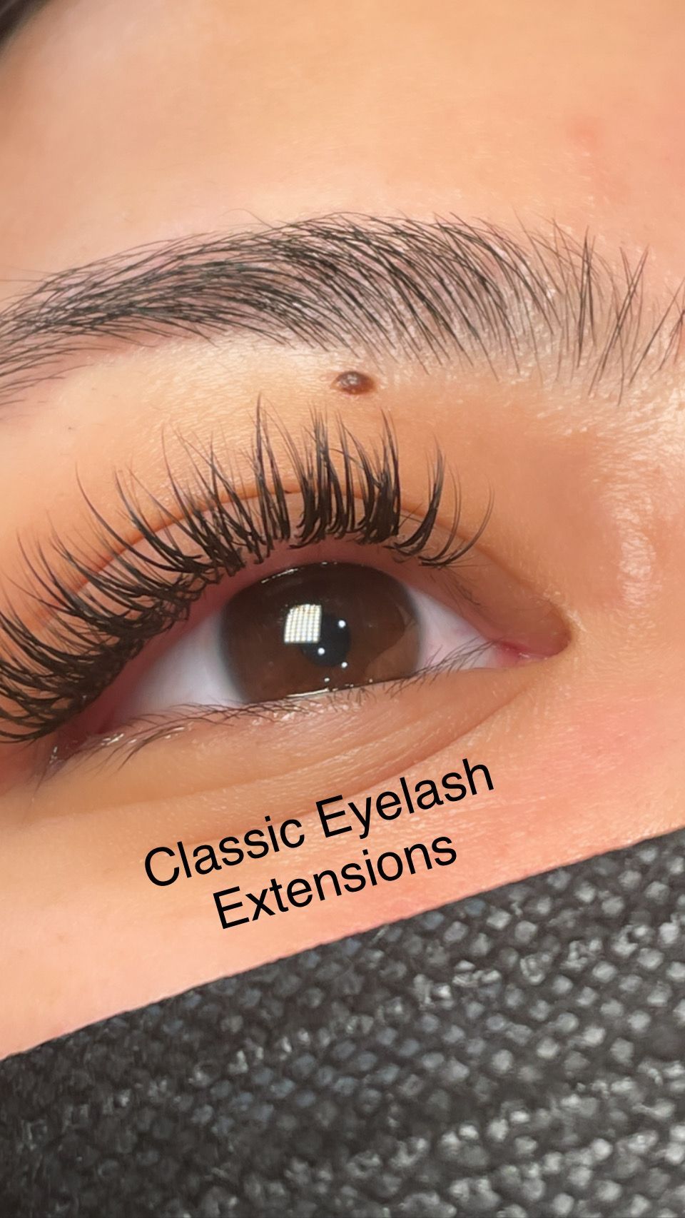 A close up of a woman 's eye with classic eyelash extensions.