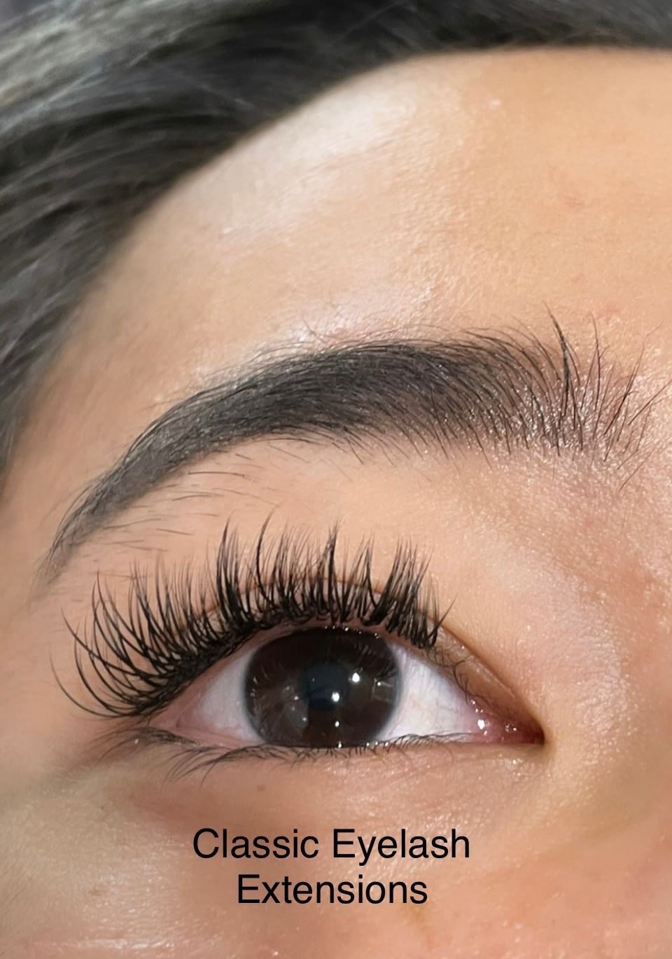 A close up of a woman 's eye with classic eyelash extensions.