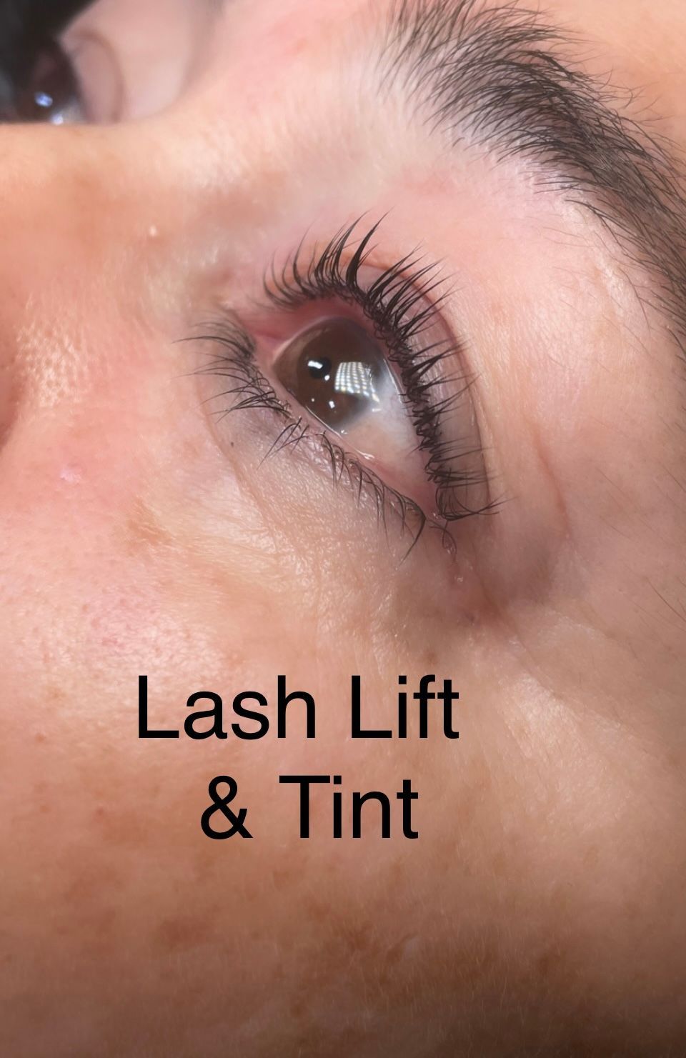 A close up of a woman 's eye with lash lift and tint