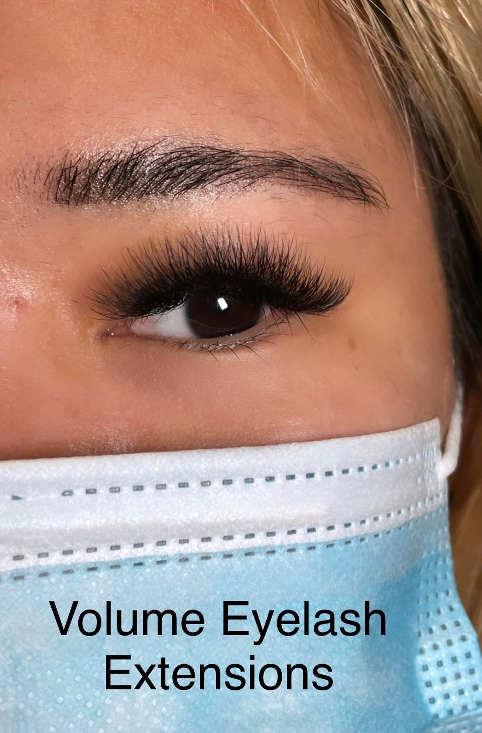 A close up of a woman wearing a mask with eyelash extensions.
