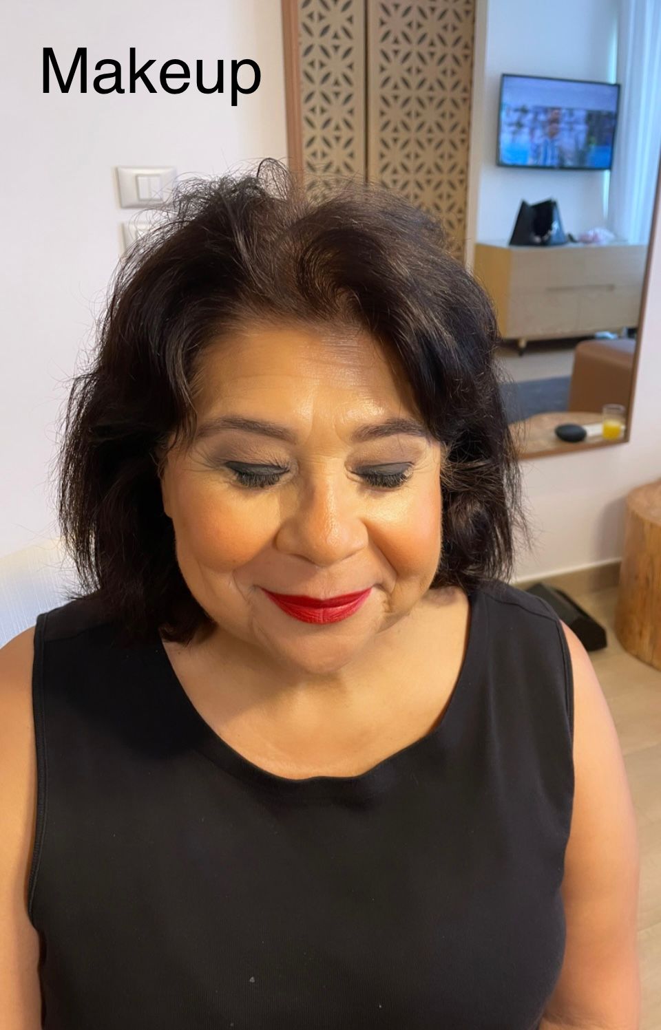 A woman is wearing a black dress and red lipstick.