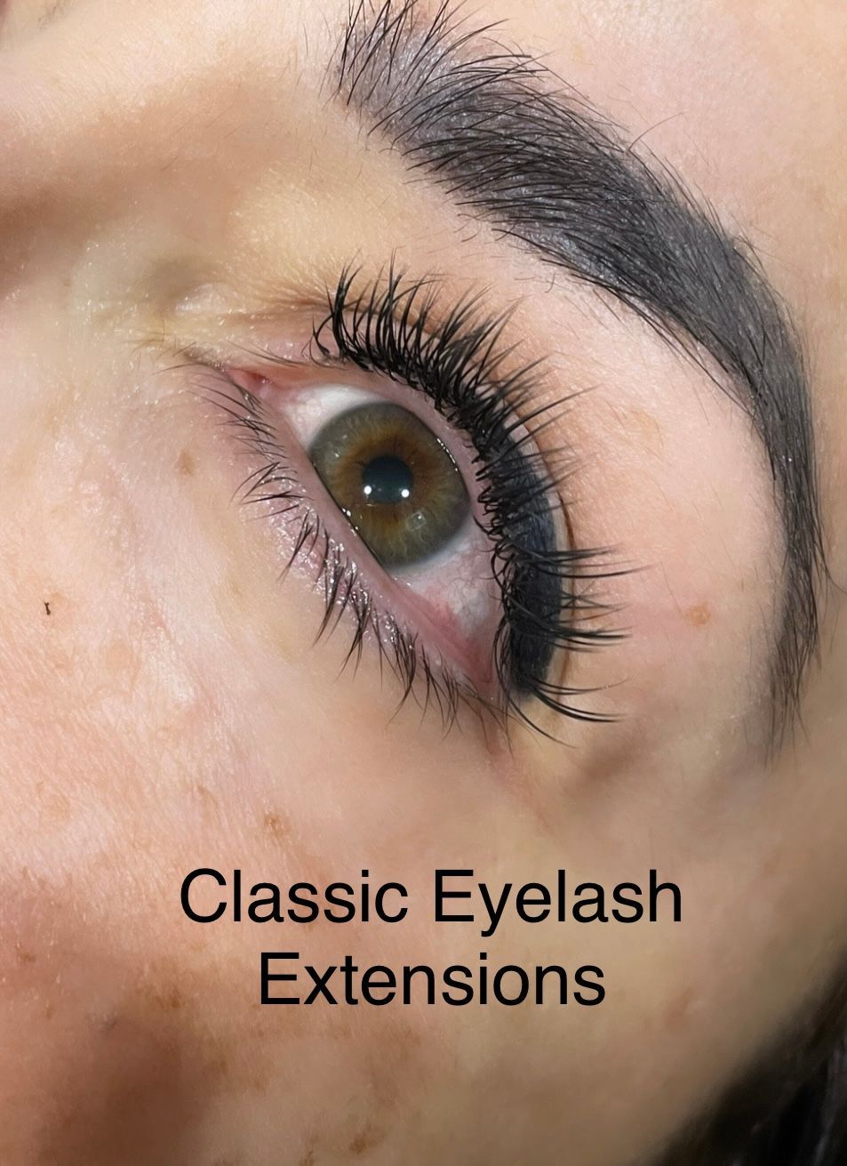A close up of a woman 's eye with classic eyelash extensions.