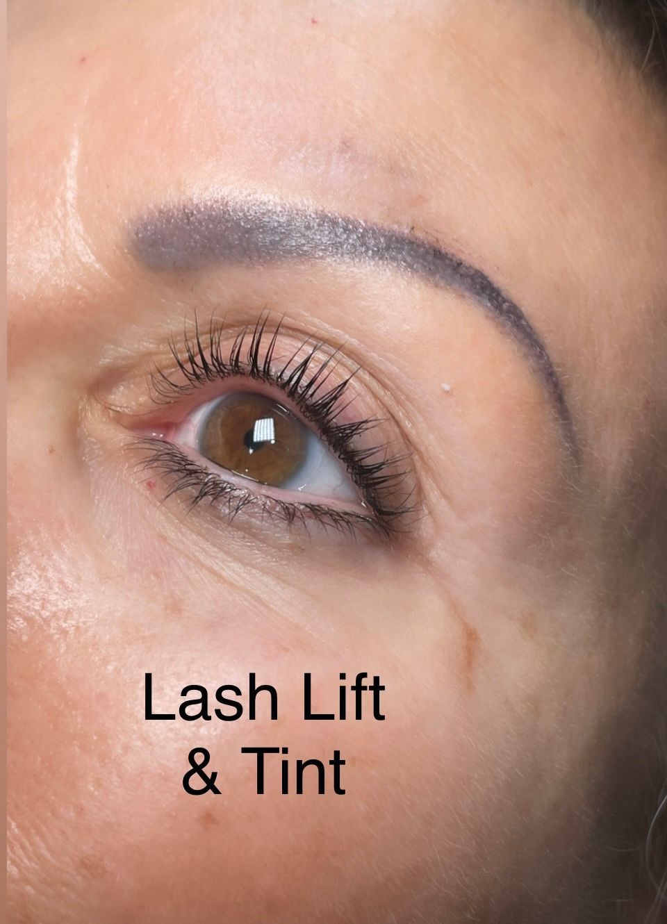 A close up of a woman 's eye with lash lift and tint