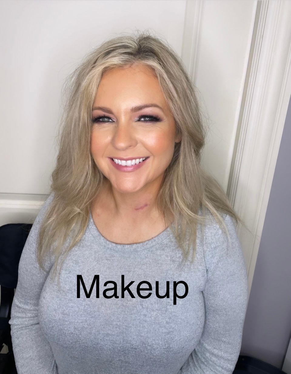 A woman wearing a grey shirt with the word makeup on it