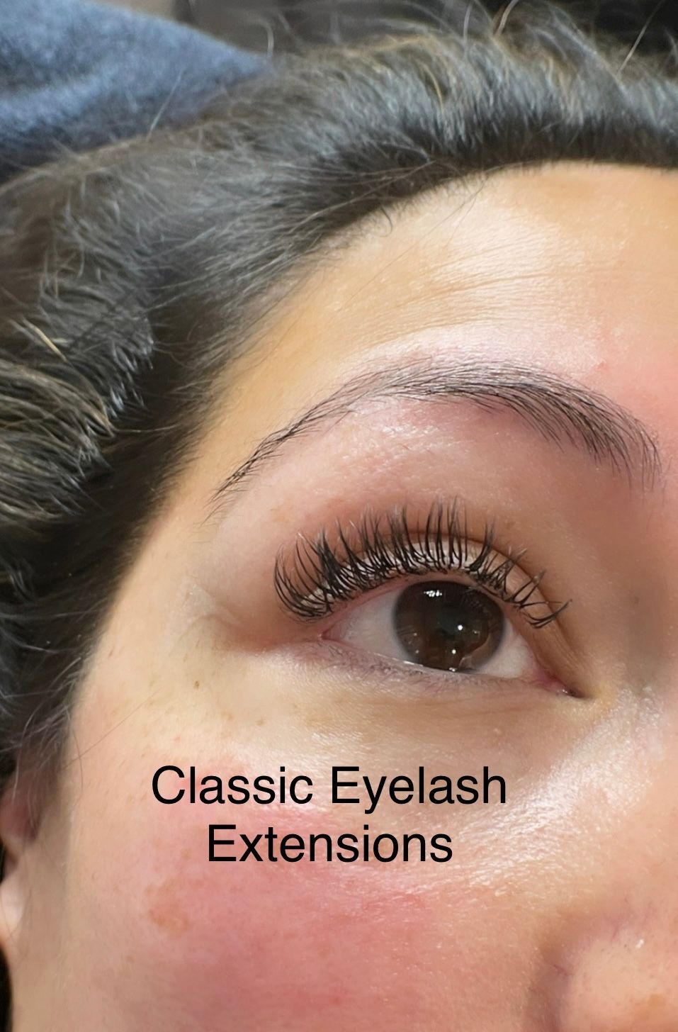 A close up of a woman 's eye with classic eyelash extensions.