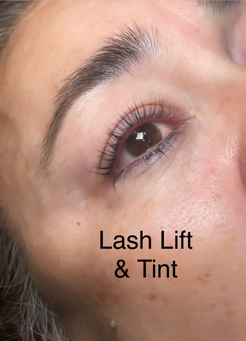 A close up of a woman 's eye with lash lift and tint.
