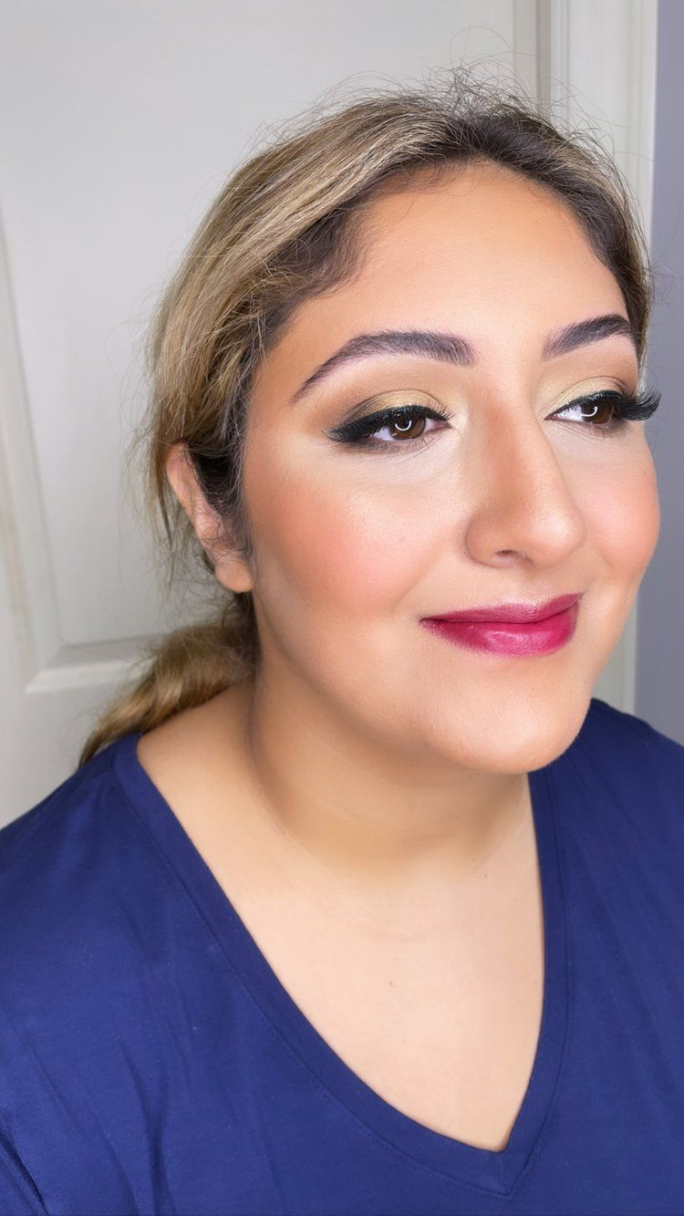 A close up of a woman wearing a blue shirt and pink lipstick.