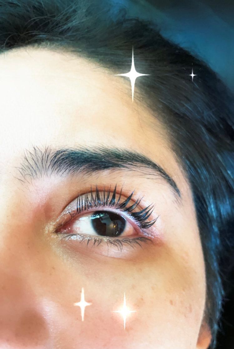 A close up of a woman 's eye with stars around it.