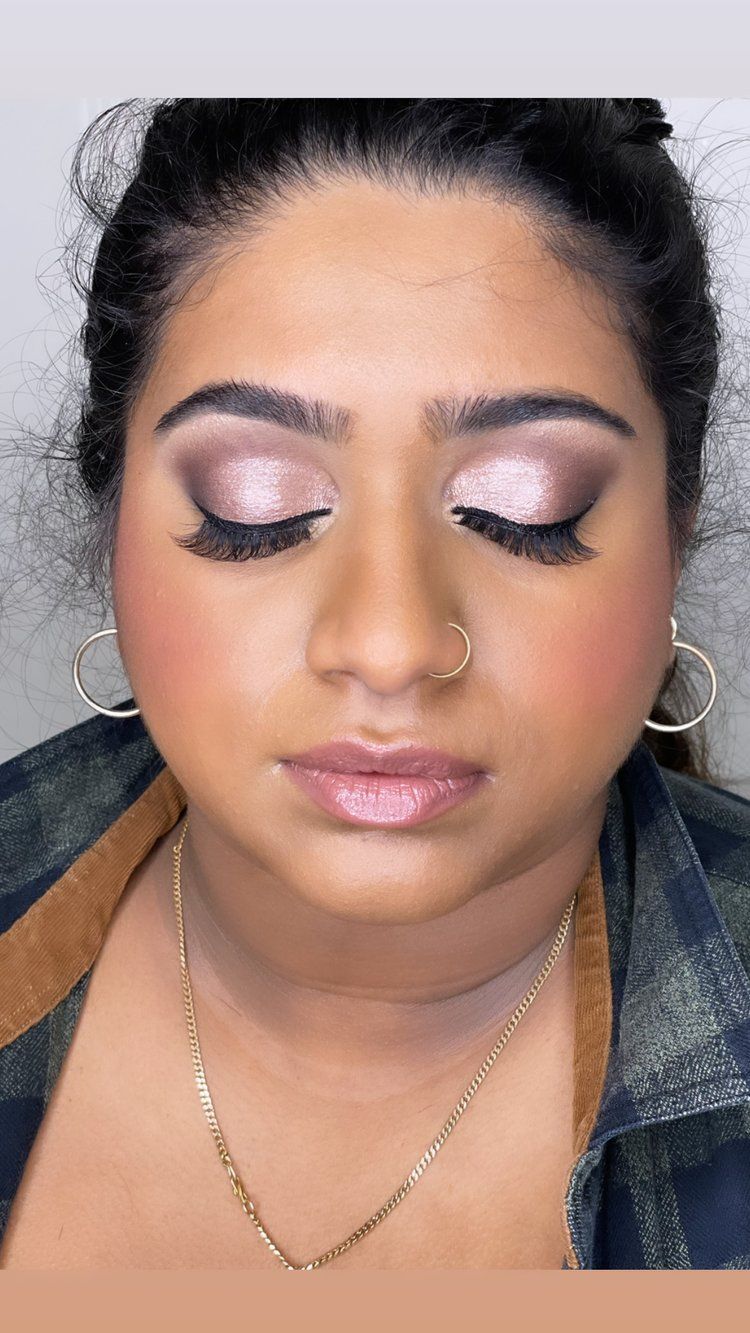 A close up of a woman wearing makeup and a nose ring.