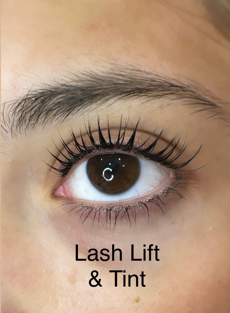 A close up of a woman 's eye with lash lift and tint.