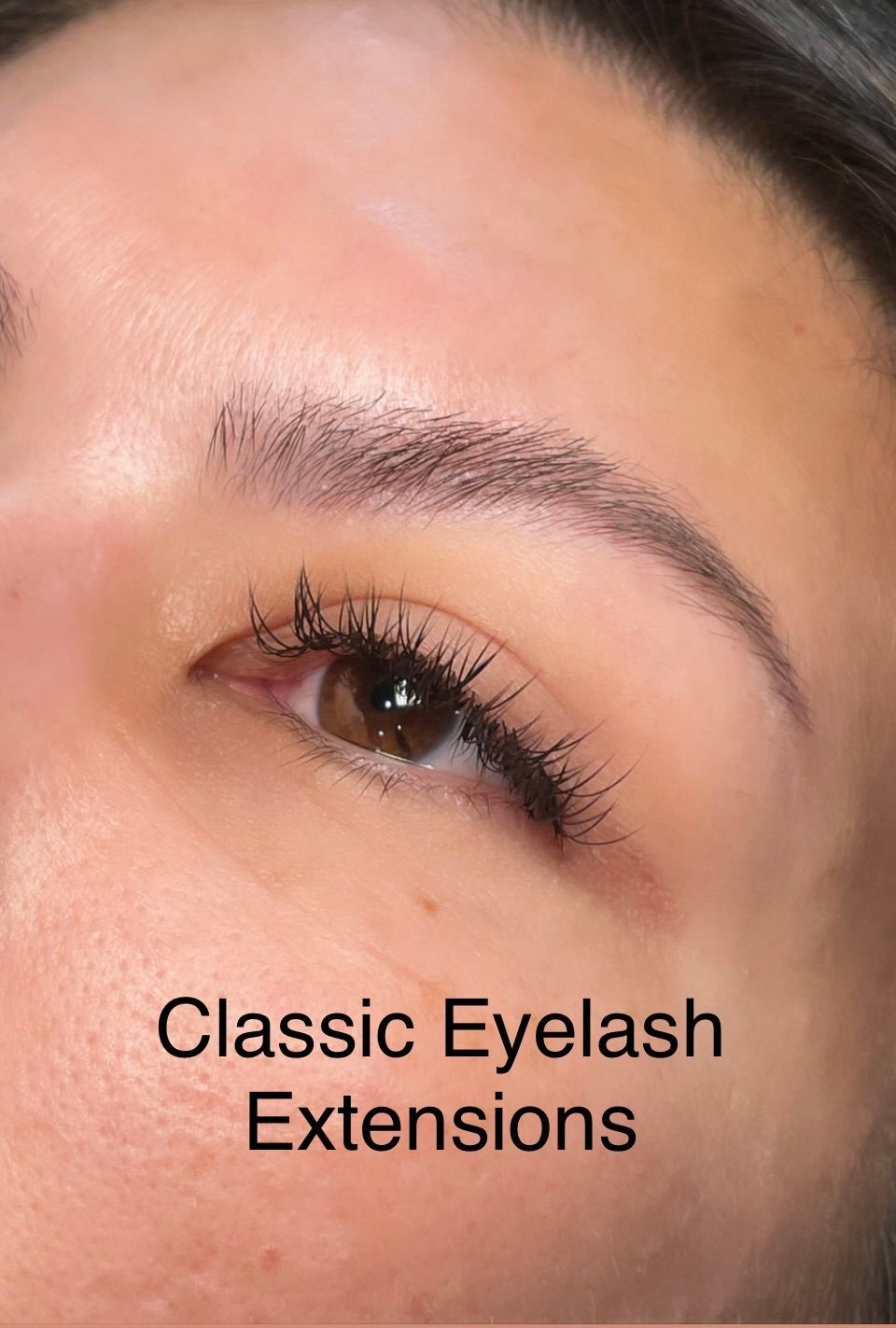 A close up of a woman 's eye with classic eyelash extensions.