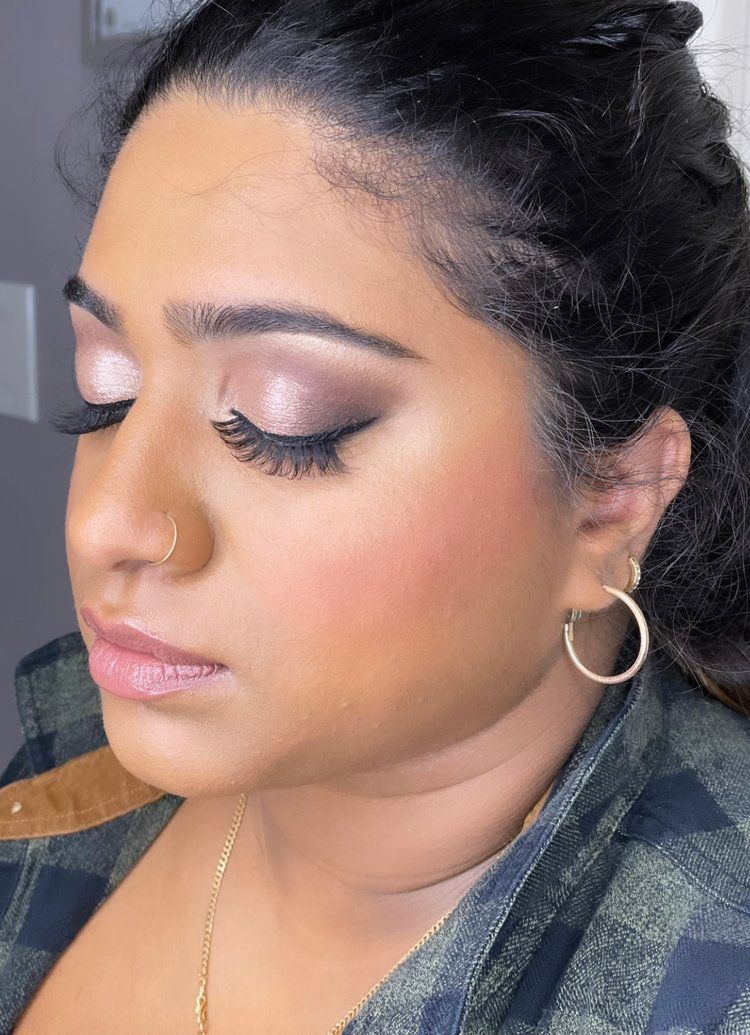 A close up of a woman 's face with makeup and earrings.