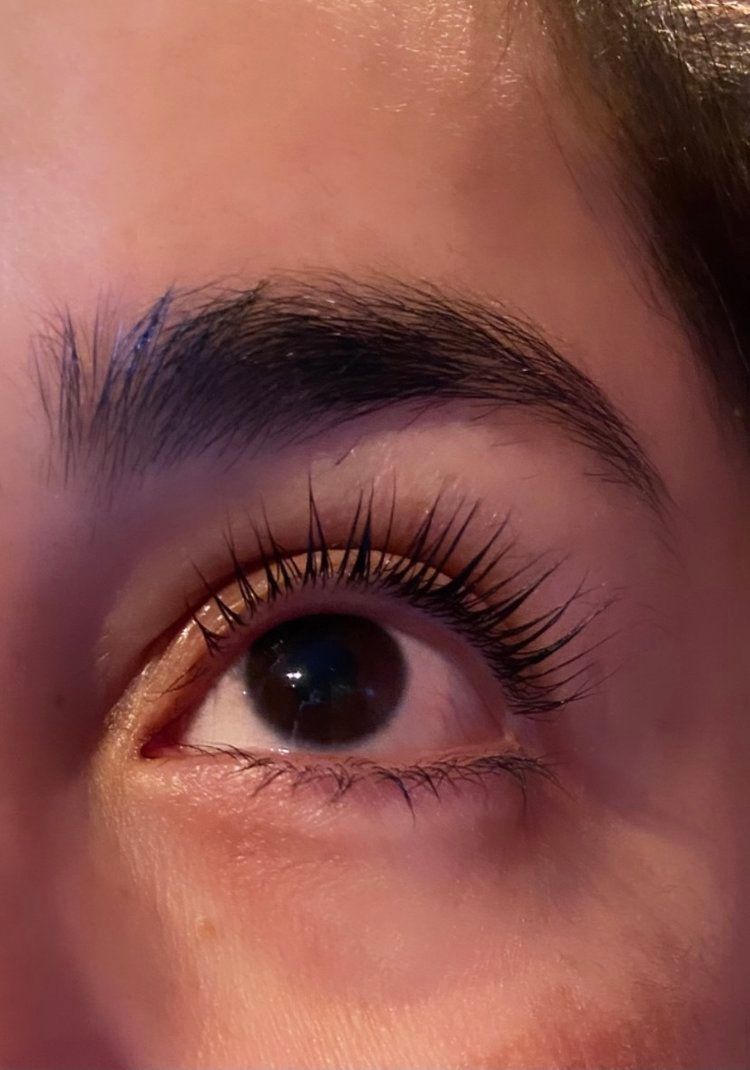 A close up of a woman 's eye with long eyelashes.