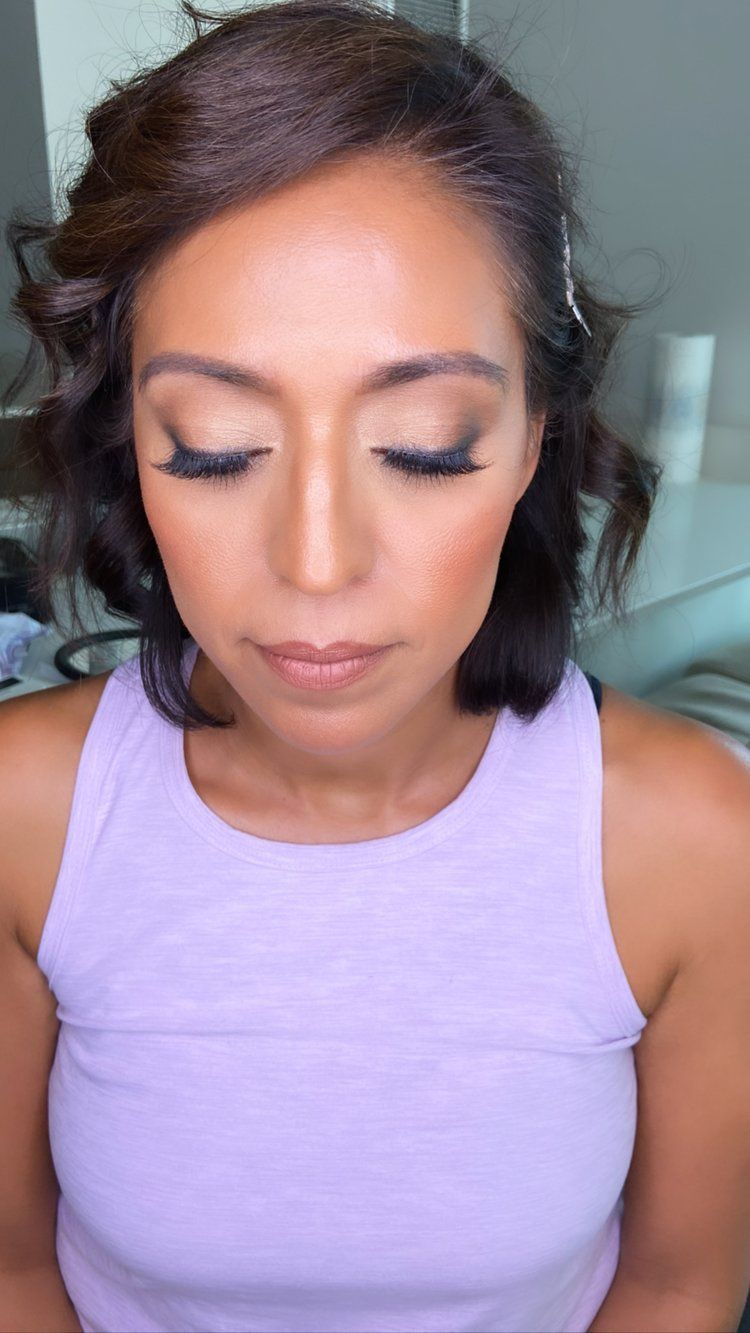 The woman is wearing a purple tank top and has her eyes closed.