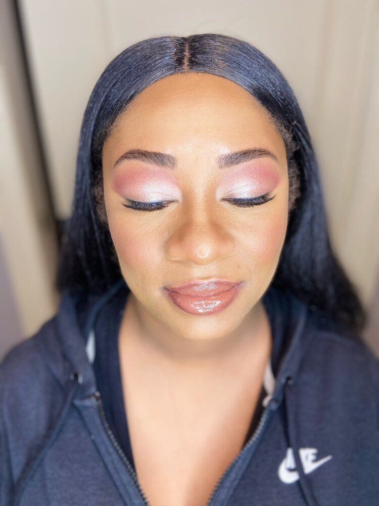 A woman wearing a blue nike hoodie with her eyes closed