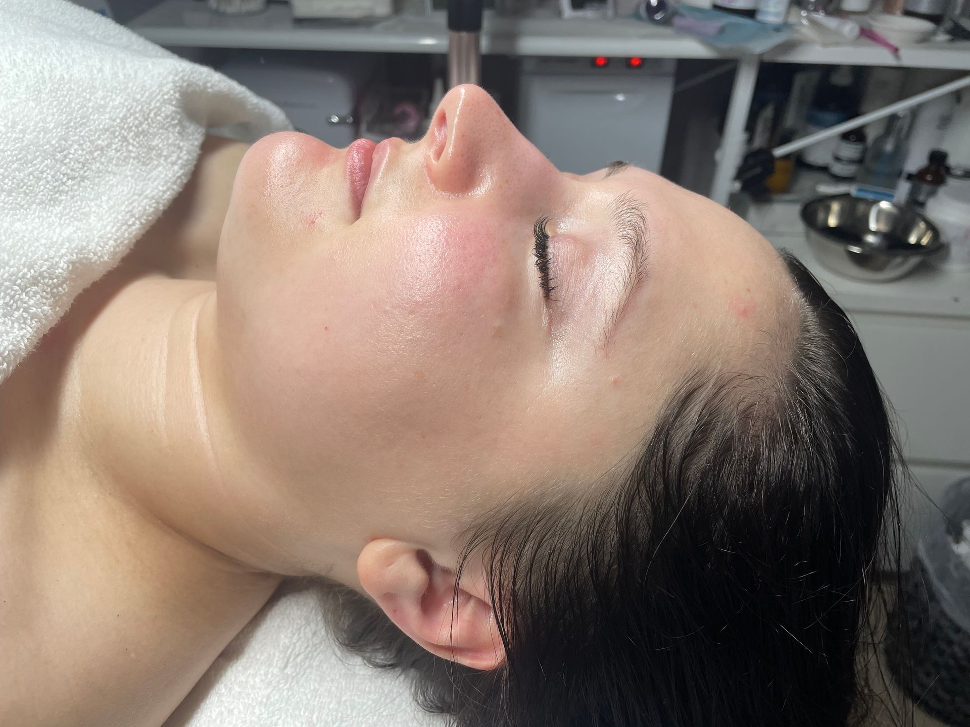 A woman is laying on a table with her eyes closed.