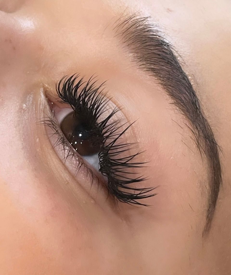 A close up of a woman 's eye with long eyelashes.