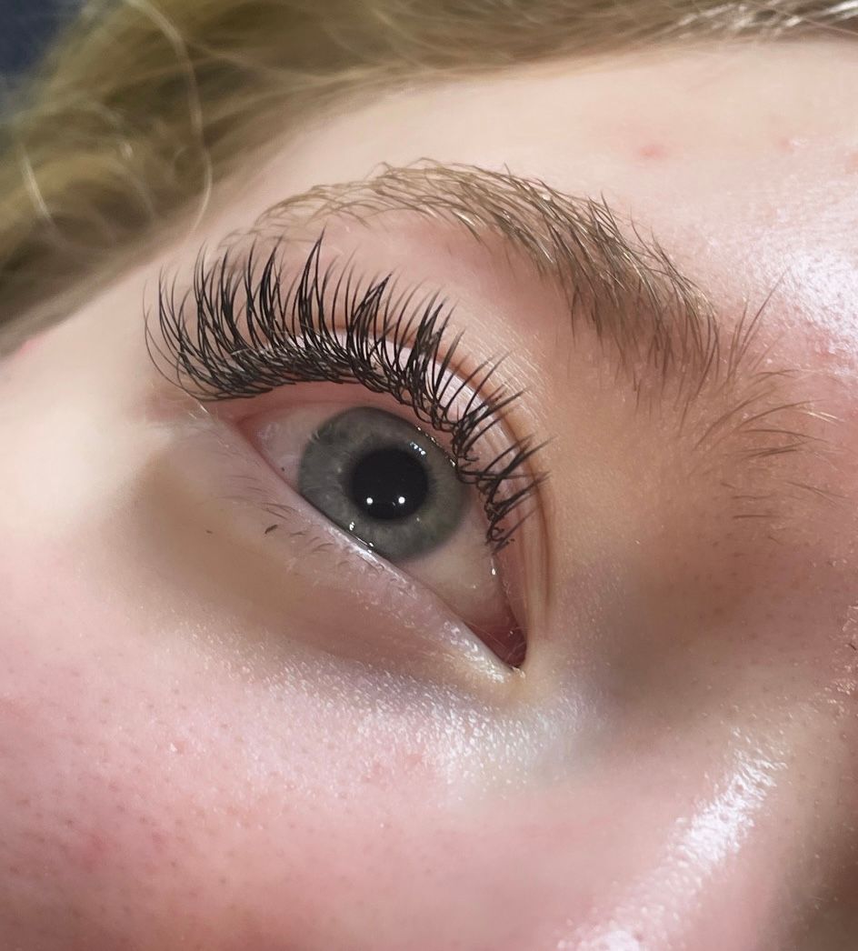 A close up of a woman 's eye with long eyelashes.