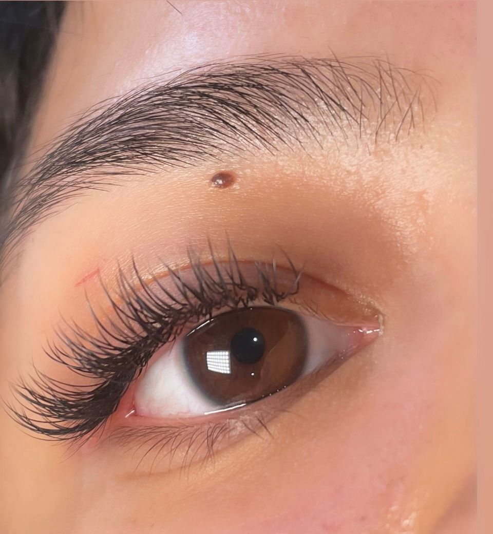 A close up of a woman 's eye with long eyelashes.