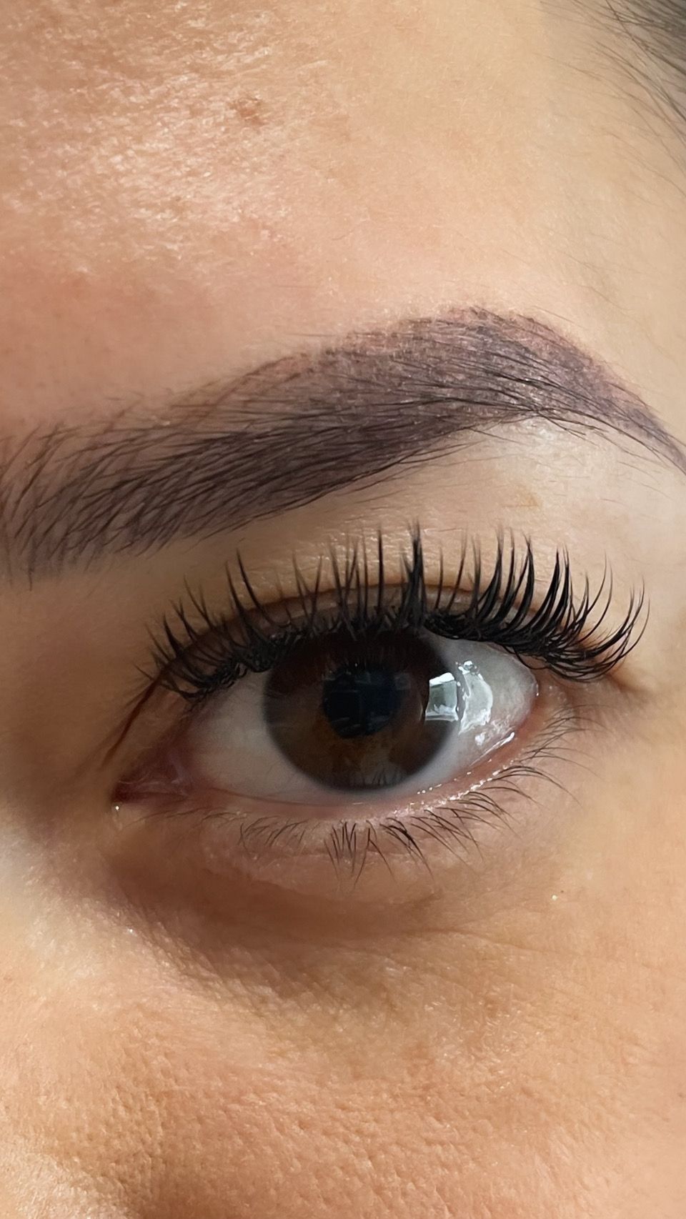 A close up of a woman 's eye with long eyelashes.