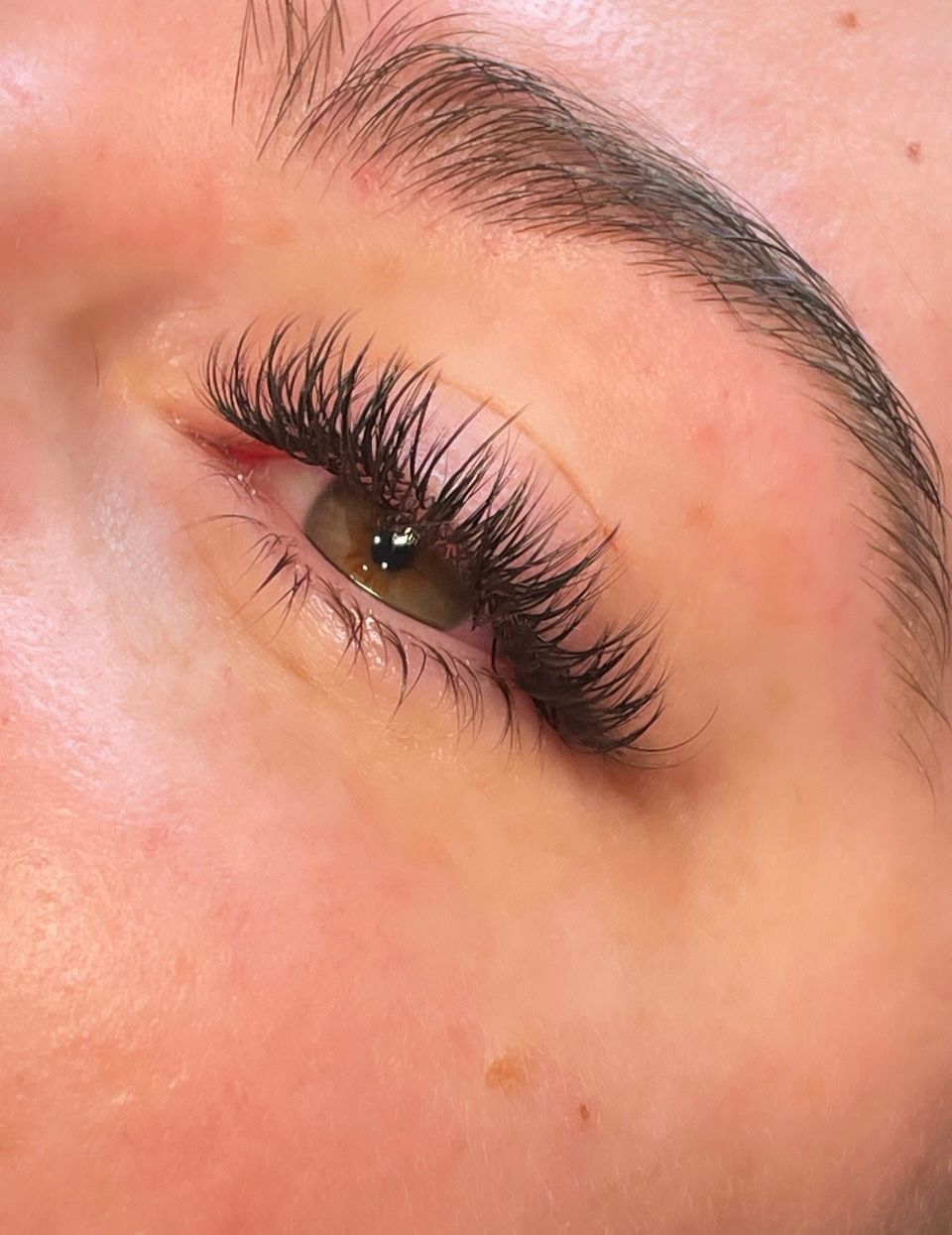 A close up of a woman 's eye with long eyelashes.