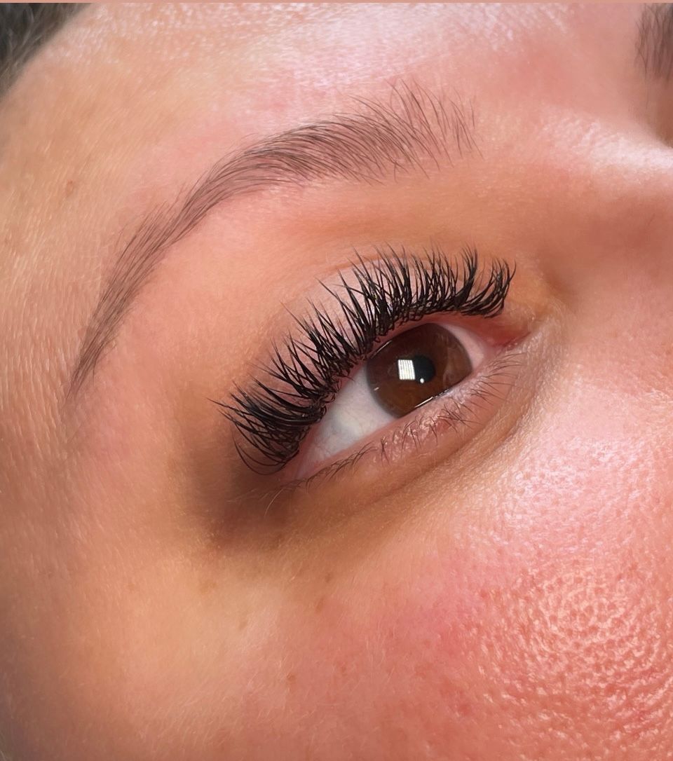 A close up of a woman 's eye with long eyelashes.