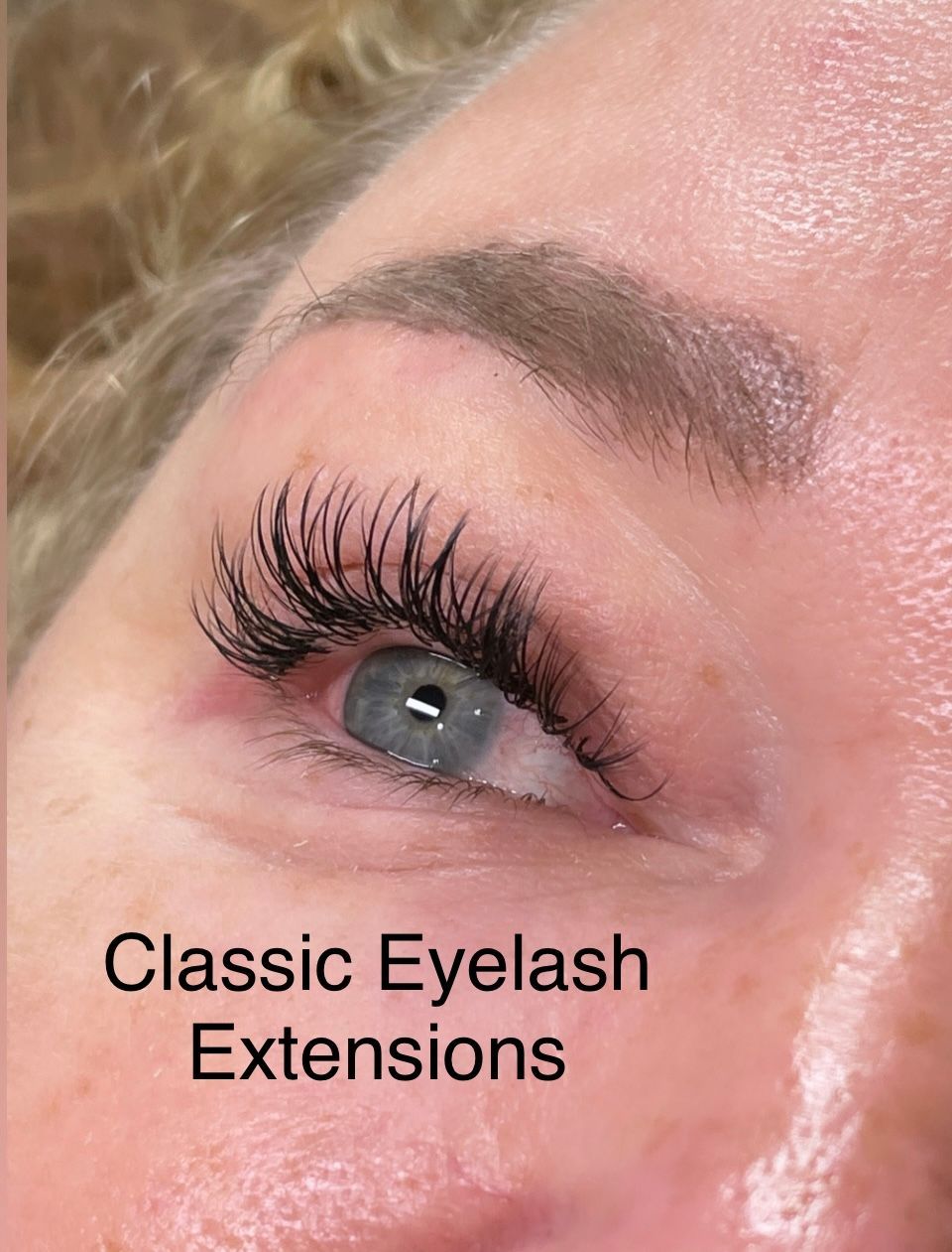 A close up of a woman 's eye with classic eyelash extensions.