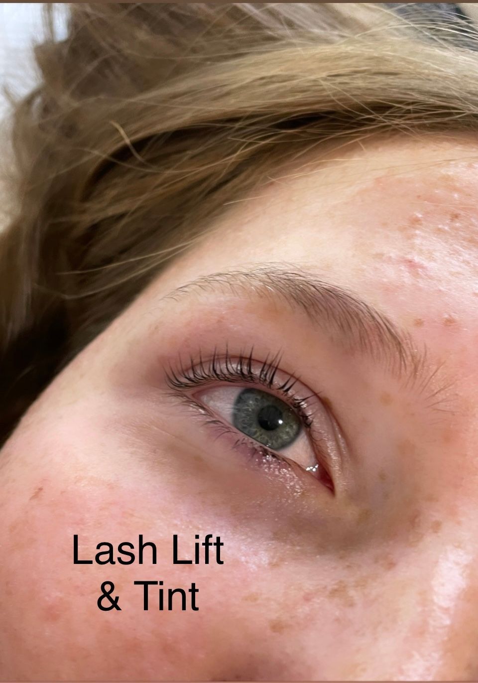 A close up of a woman 's eye with a lash lift and tint.