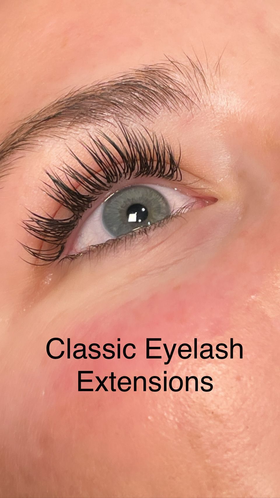 A close up of a woman 's eye with classic eyelash extensions.