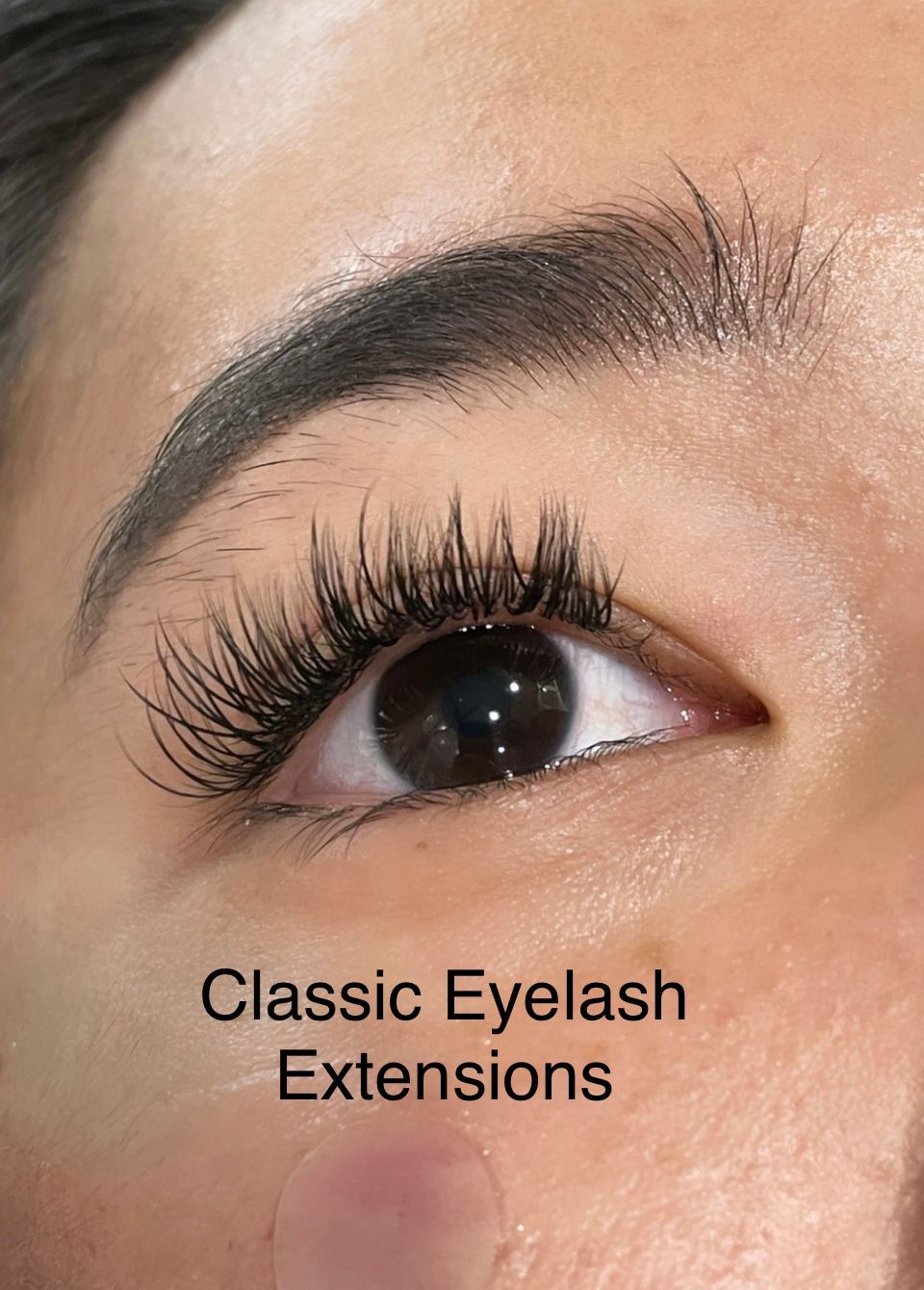 A close up of a woman 's eye with classic eyelash extensions.