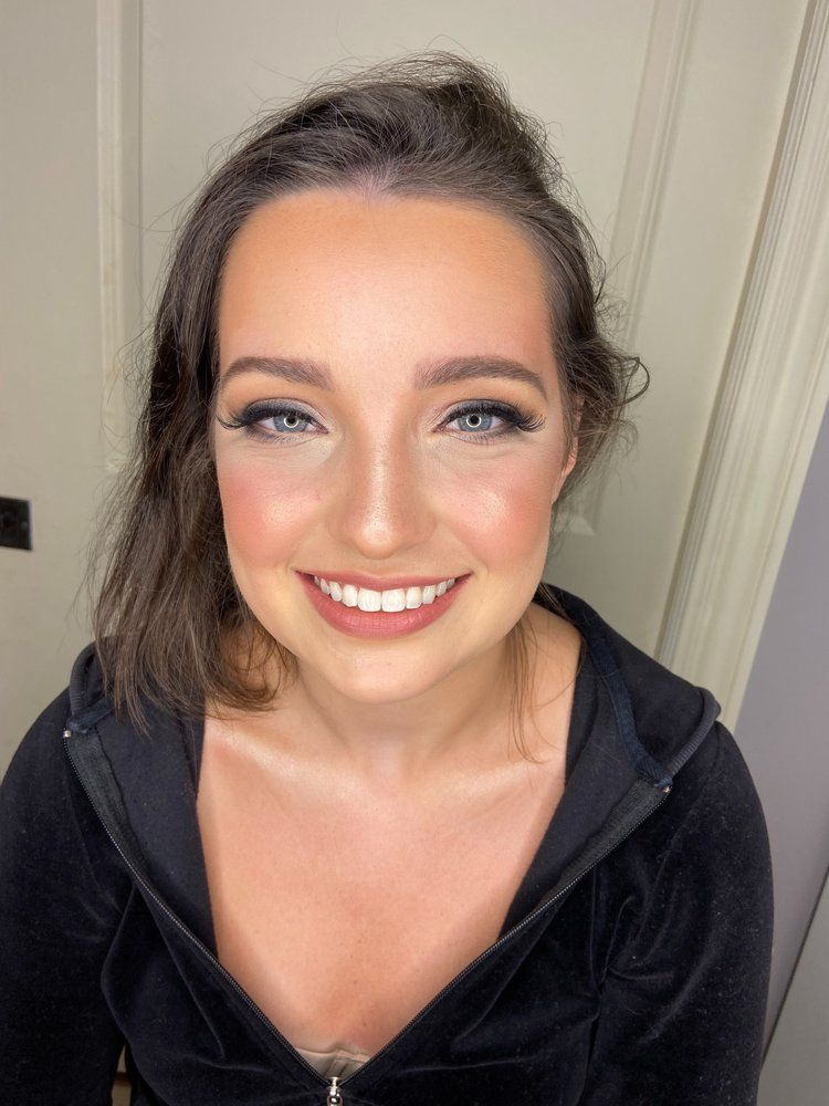A close up of a woman wearing a black hoodie and smiling.