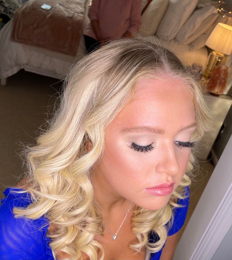 A close up of a woman 's face with blonde hair and makeup.