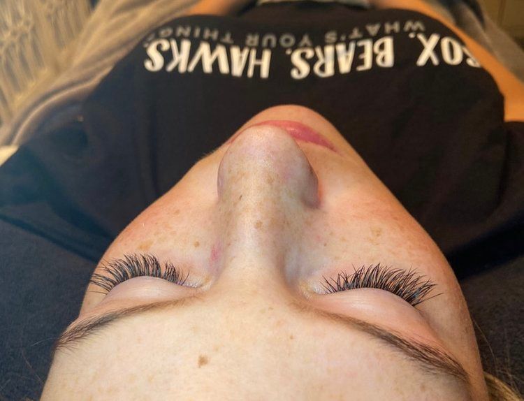 A woman wearing a black shirt that says fox bears hawks