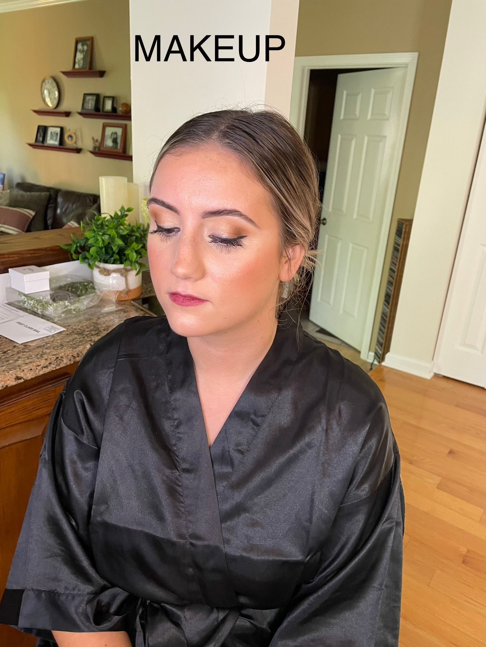 A woman is getting her makeup done in front of a sign that says makeup.