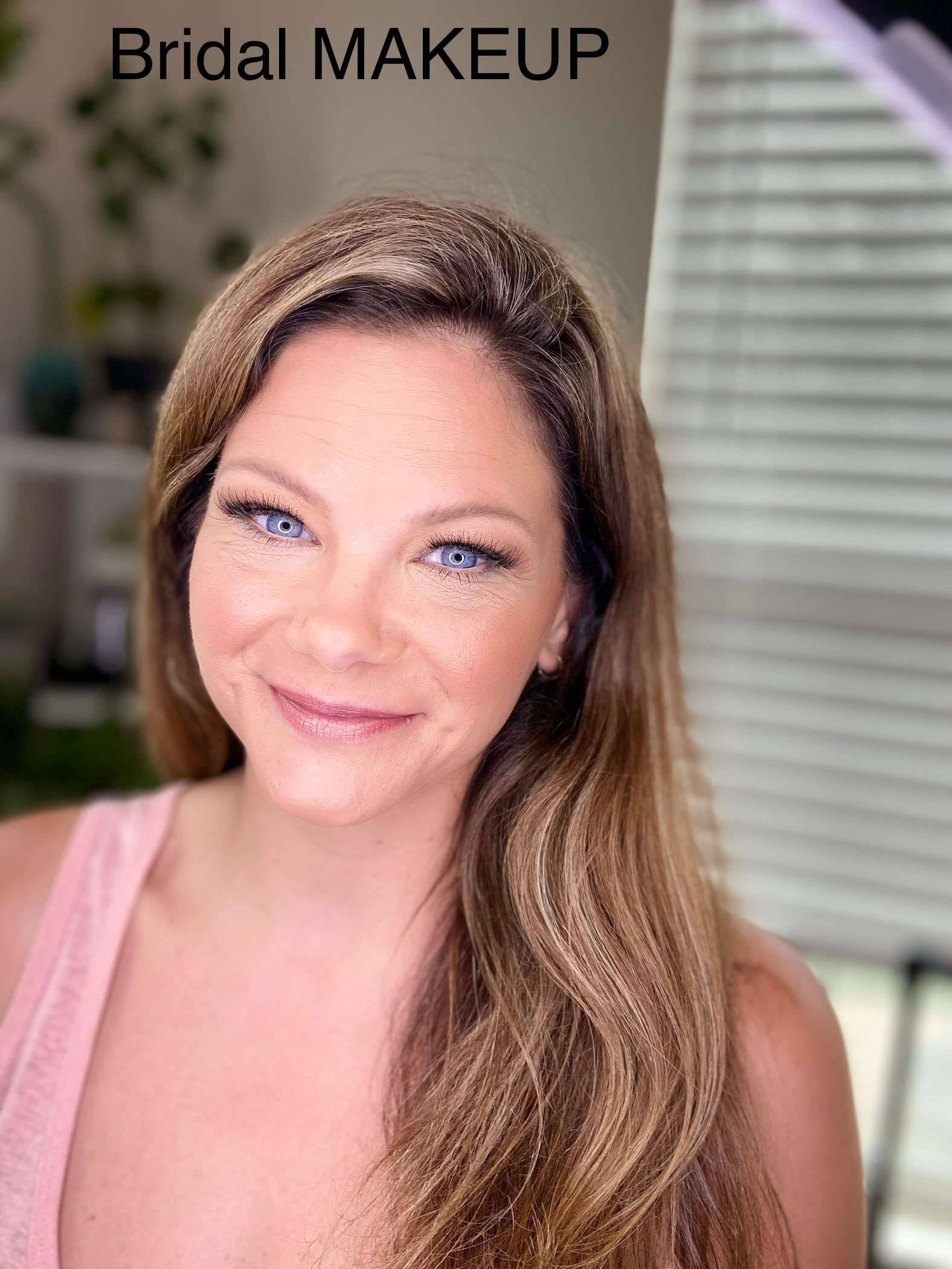 A woman with long hair and blue eyes is wearing a headband and smiling.