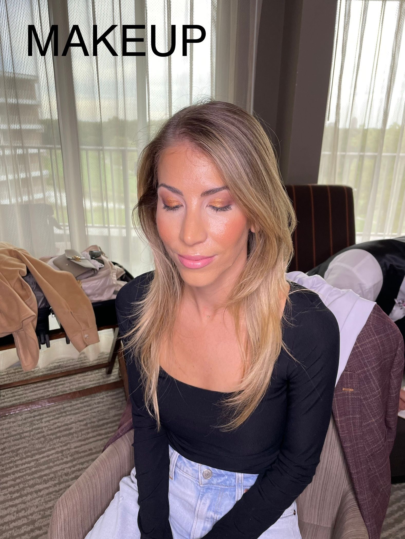 A woman is sitting in a chair with makeup on her face.