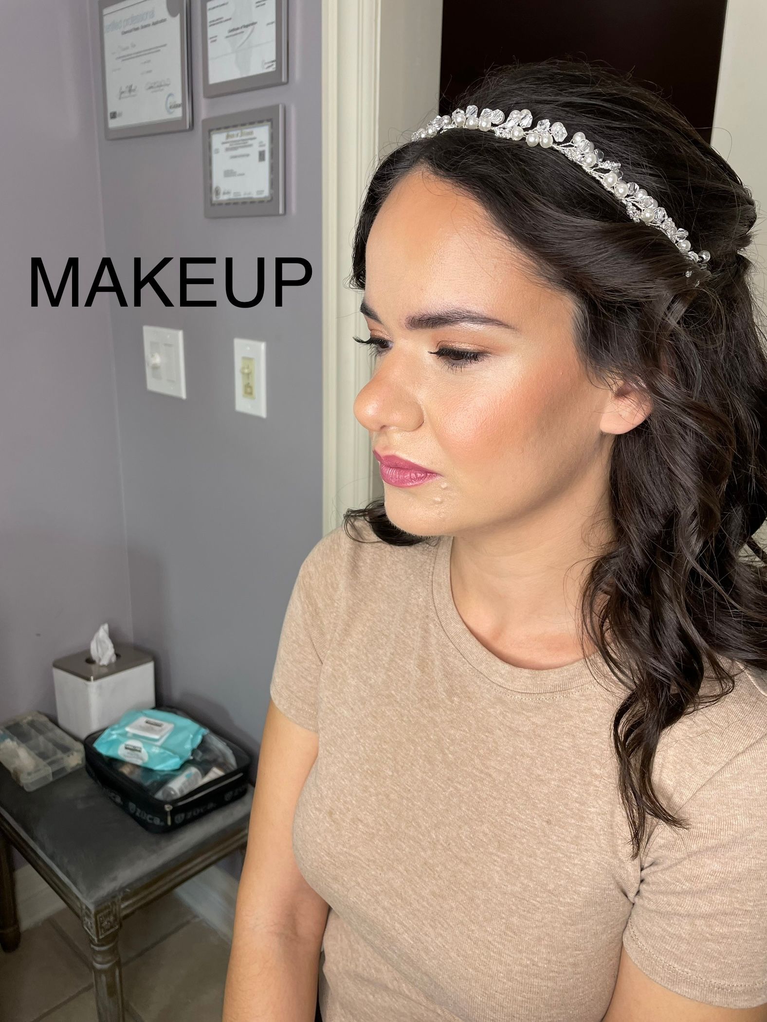 A woman is wearing a headband and a tan shirt.