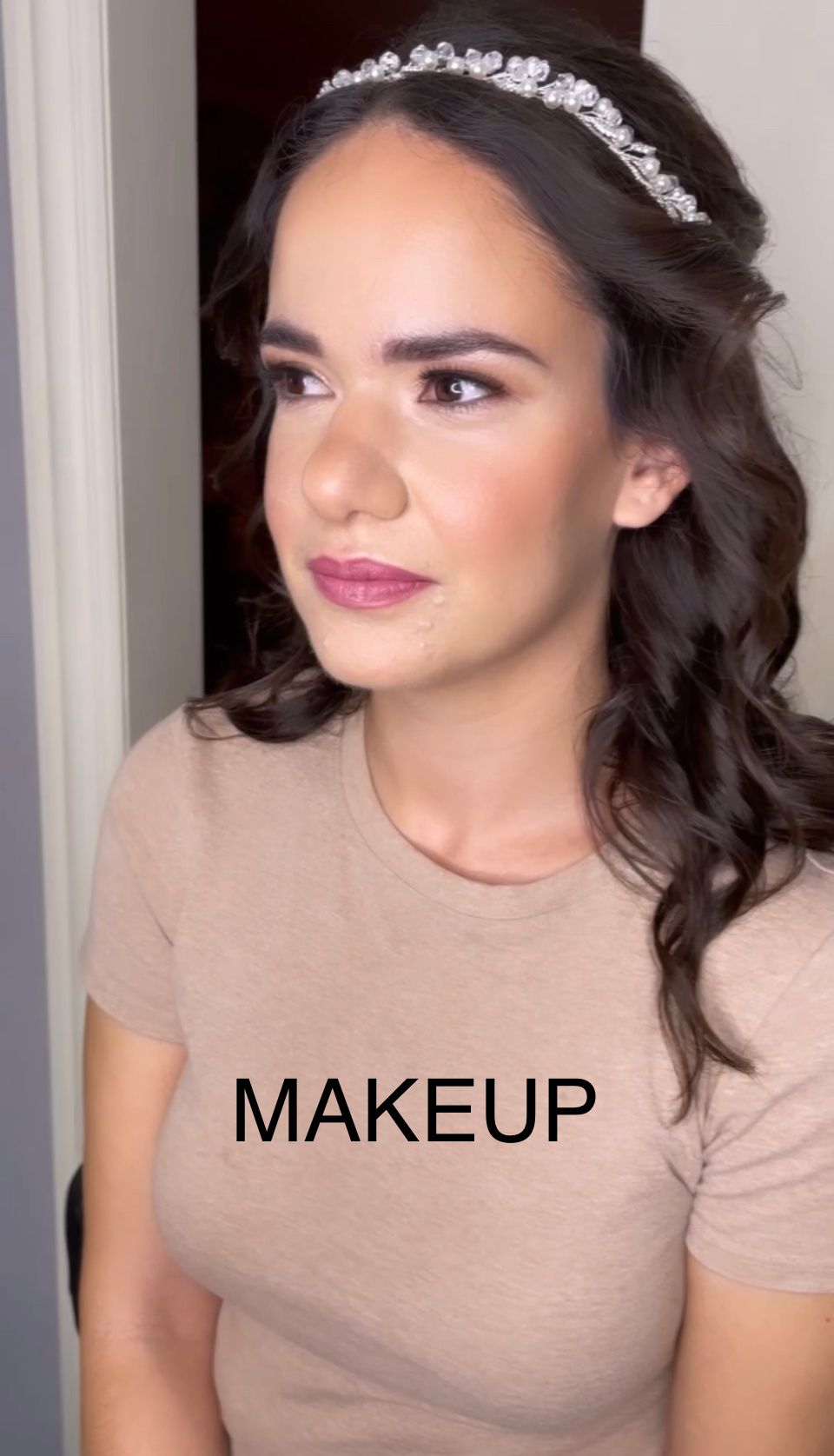 A woman wearing a headband and a t-shirt with the word makeup on it.
