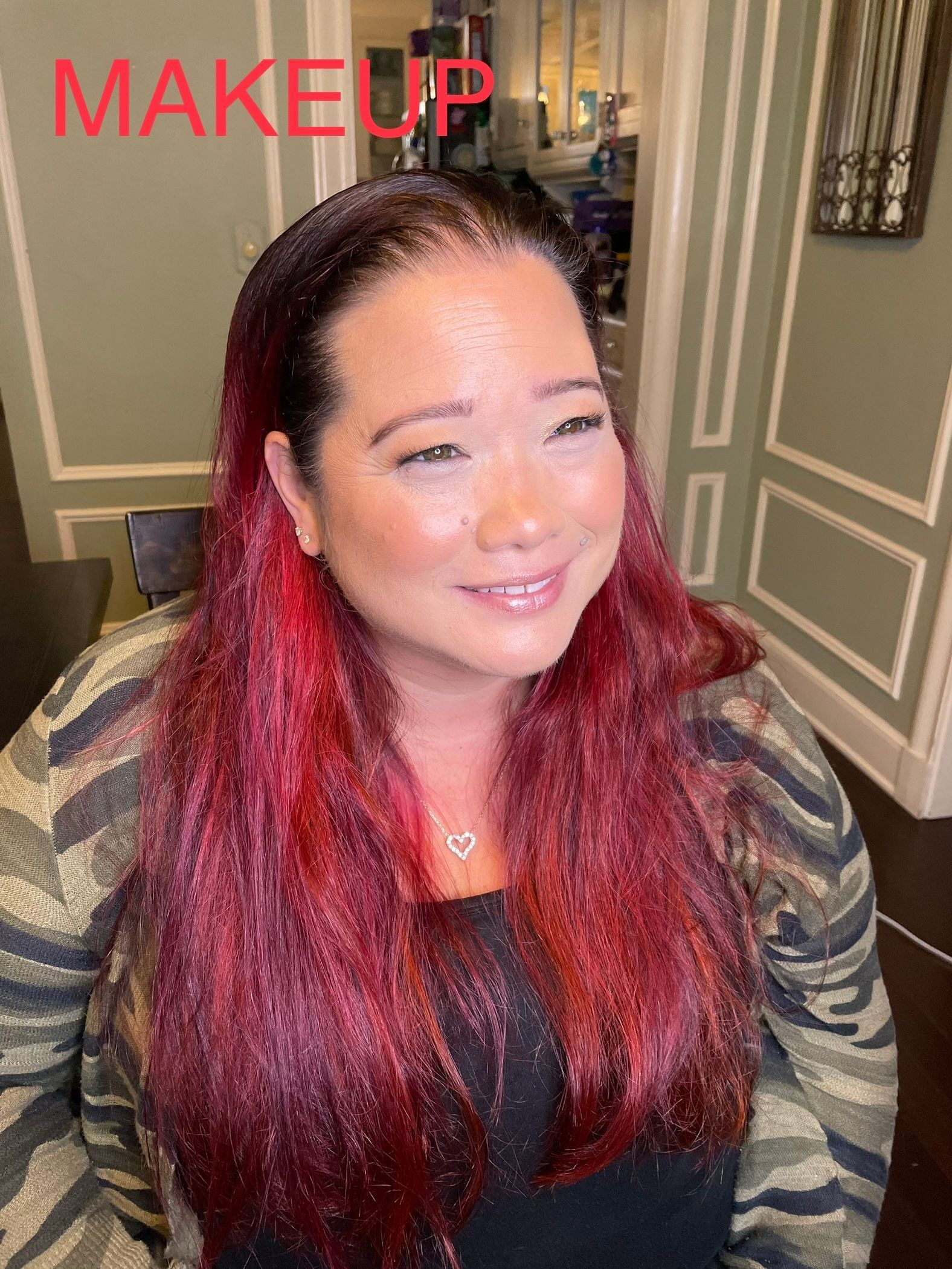 A woman with red hair is smiling and wearing a headband.