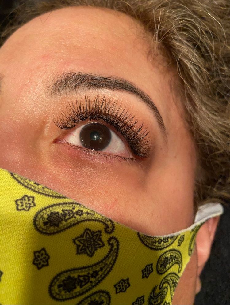 A close up of a woman 's eye wearing a yellow bandana.