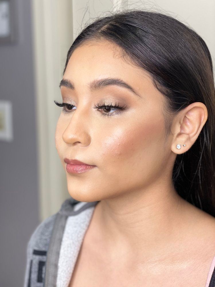 A close up of a woman 's face with makeup and earrings.