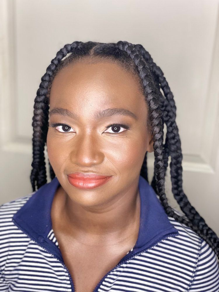 A woman with braids is wearing a blue and white striped shirt.
